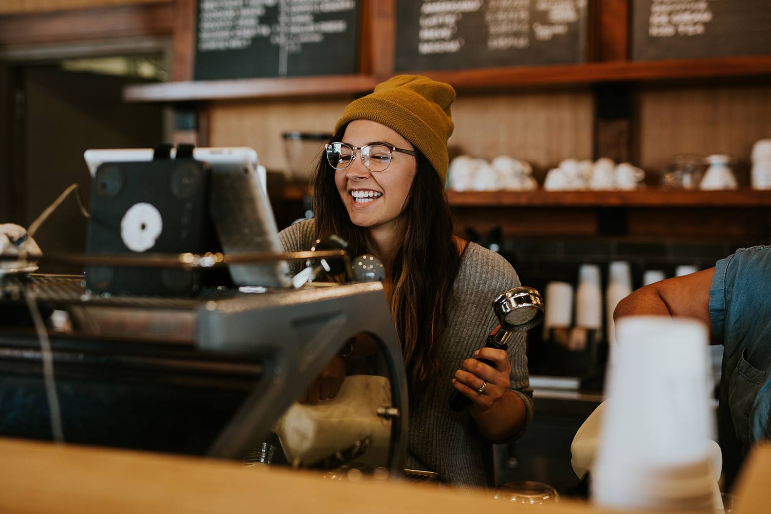 A small business owner working behind the counter of her café